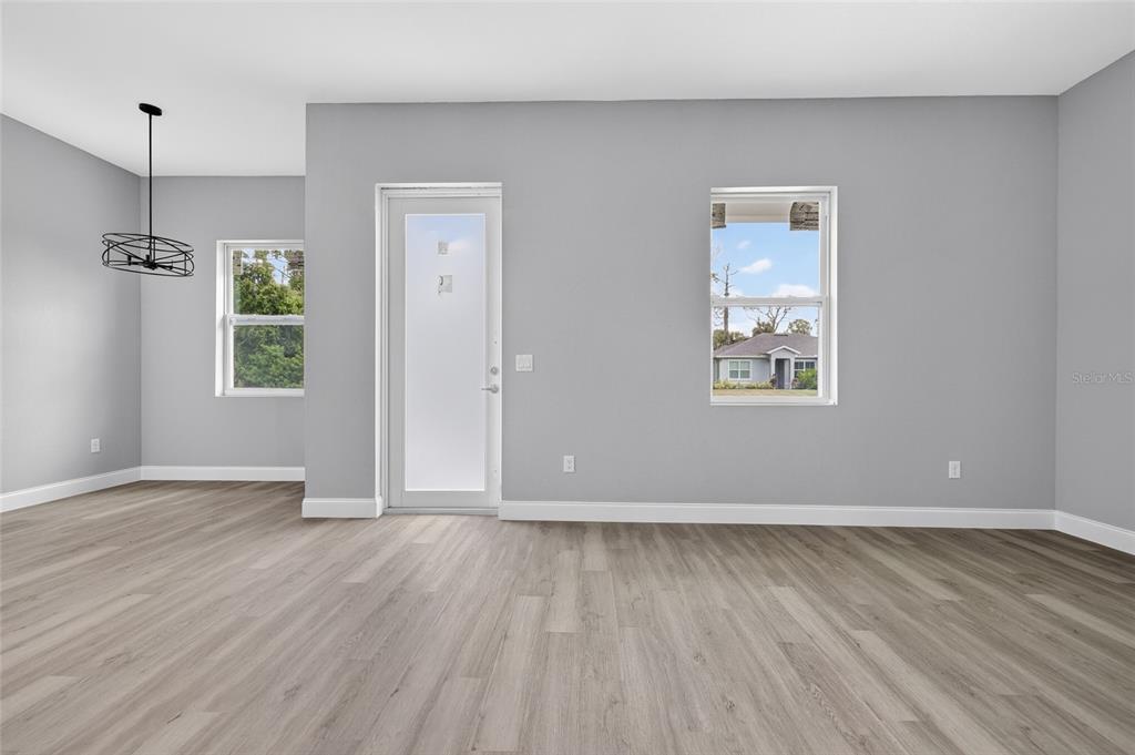 A room with gray walls, wood-look flooring, a glass-paneled door, and two windows — 369 AVELLA STREET, PORT CHARLOTTE, FL