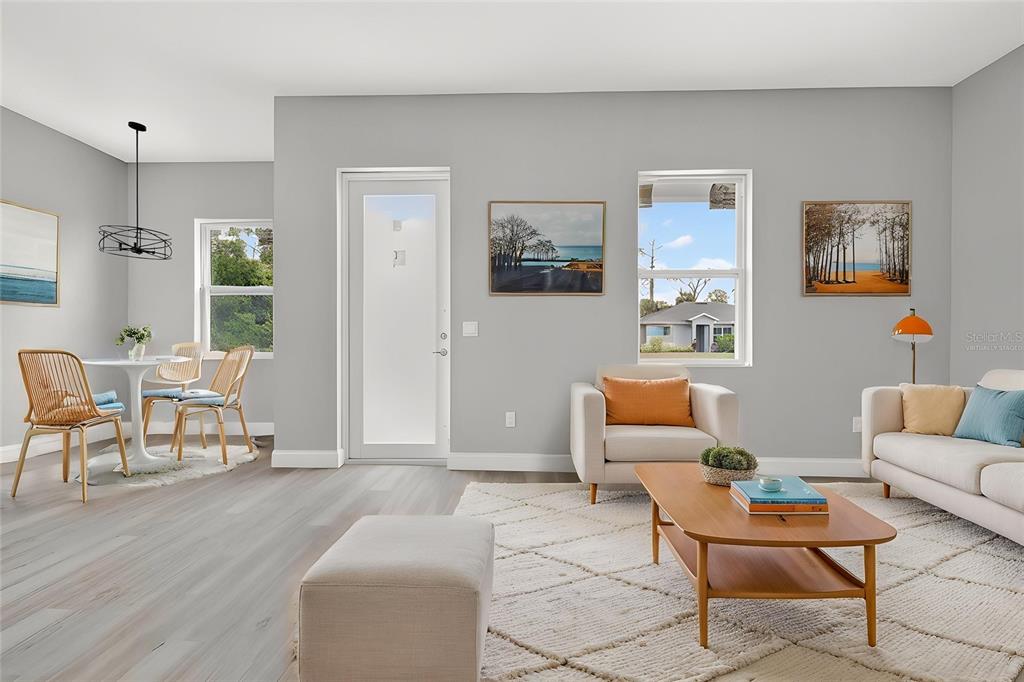 This living and dining area features light gray walls, wood-look flooring, and modern furniture — 369 AVELLA STREET, PORT CHARLOTTE, FL