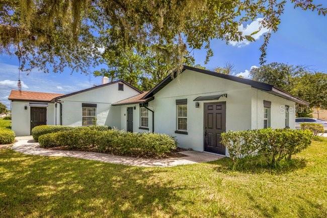 A white single-story house with a brown roof and a walkway through the front yard — 604 N SINCLAIR AVENUE, TAVARES, FL