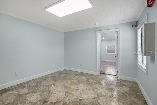 A room with light blue walls, tile flooring, a white ceiling, and a doorway — 604 N SINCLAIR AVENUE, TAVARES, FL
