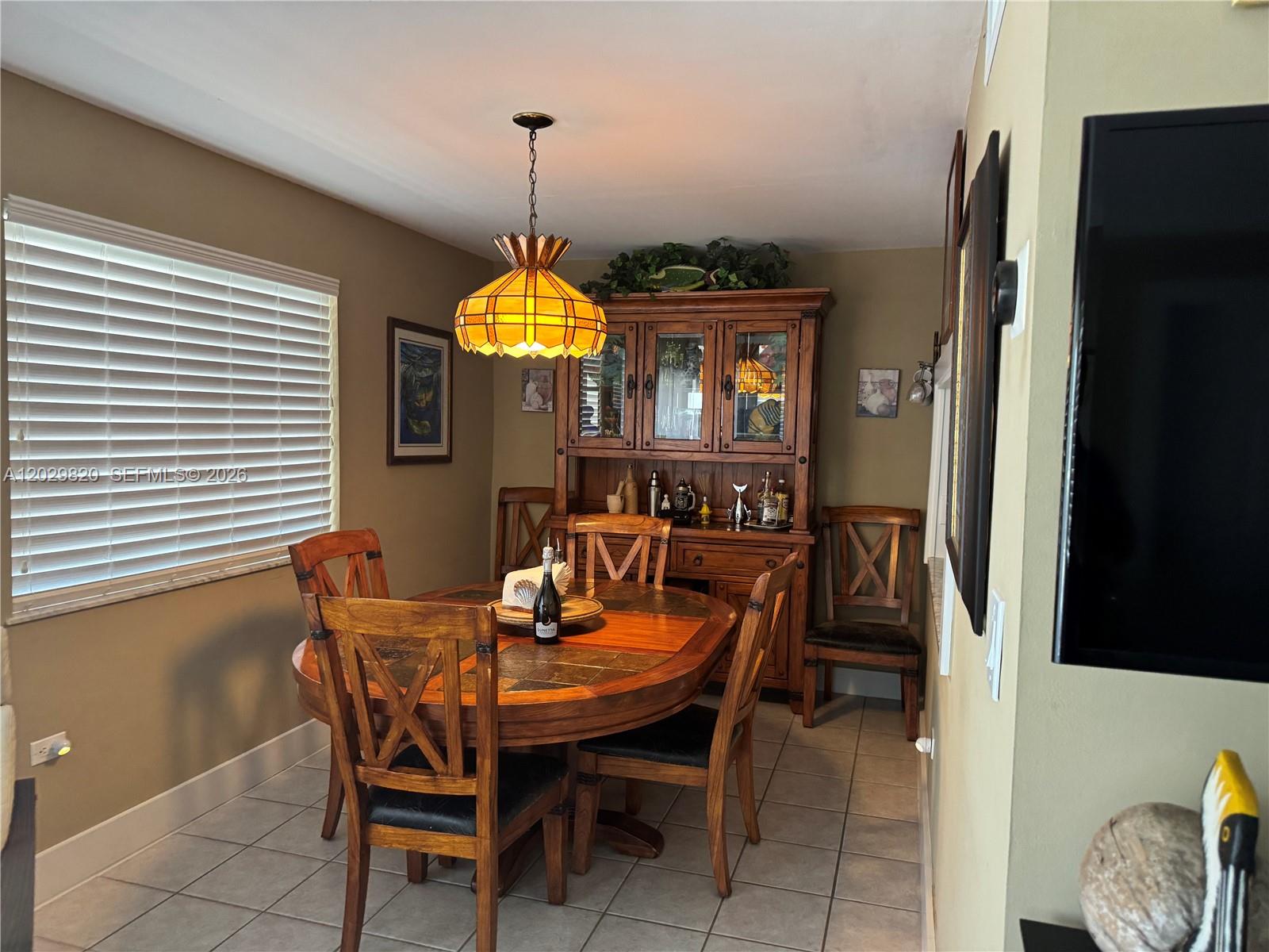 A dining room features a round wooden table, matching chairs, and a large hutch — 118 Cortez Dr # B, Islamorada FL 33036, ISLAMORADA, FL