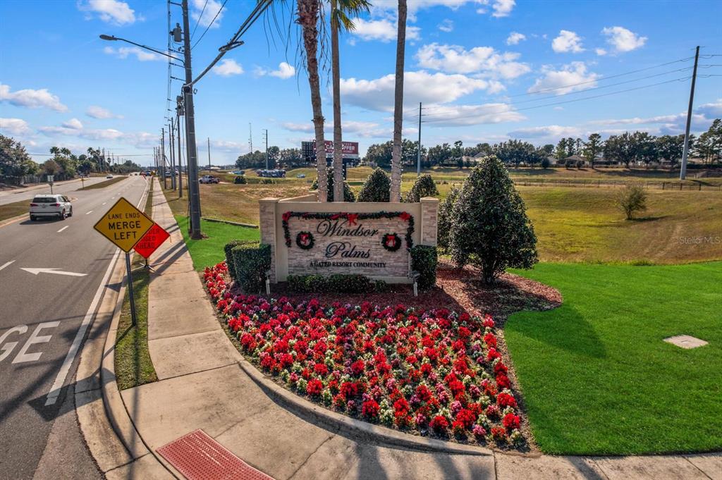 A stone monument sign for Windsor Palms resort community sits beside a road with landscaping — 2310 SILVER PALM DRIVE UNIT 201, KISSIMMEE, FL