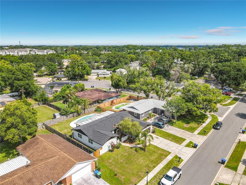 An aerial view shows a suburban neighborhood with houses, swimming pools, and tree-lined streets — 8676 HILLSIDE DRIVE, ORLANDO, FL