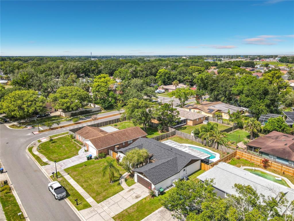 An aerial view shows a suburban neighborhood with single-family homes, lawns, and swimming pools — 8676 HILLSIDE DRIVE, ORLANDO, FL