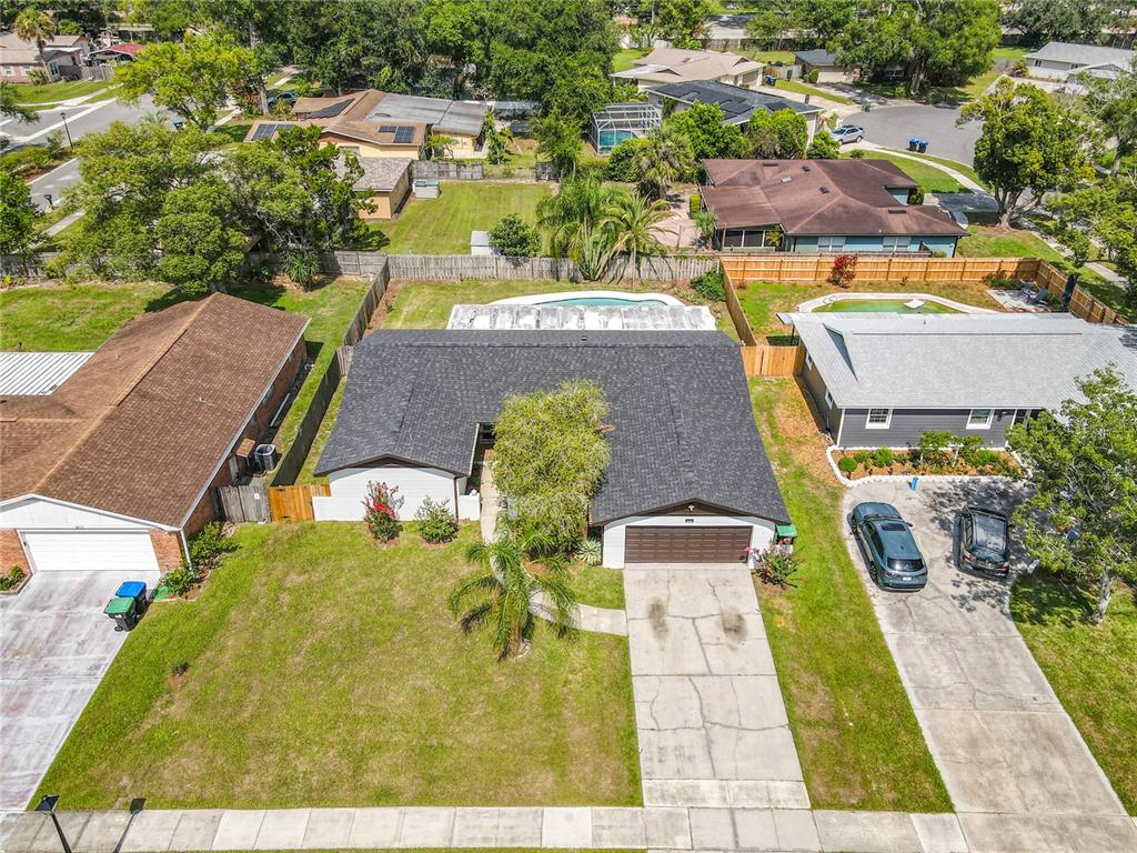 An aerial view shows a single-story house with a dark roof, driveway, and backyard pool — 8676 HILLSIDE DRIVE, ORLANDO, FL