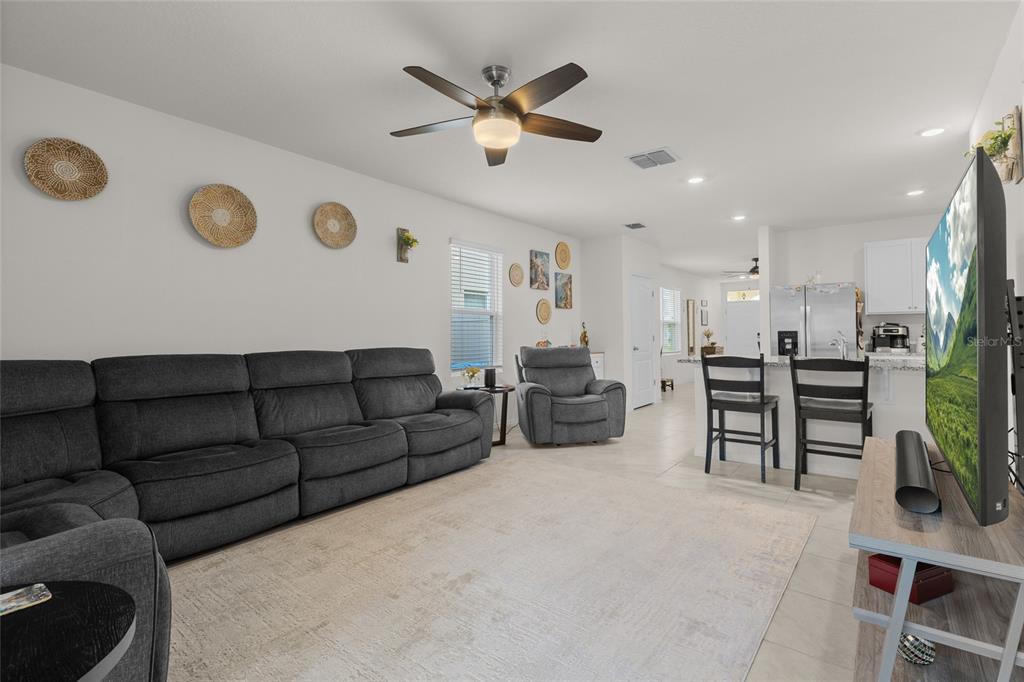 A living room features a large gray sectional sofa, a matching armchair, and a television — 1452 CUMBERLAND AVENUE, DAVENPORT, FL
