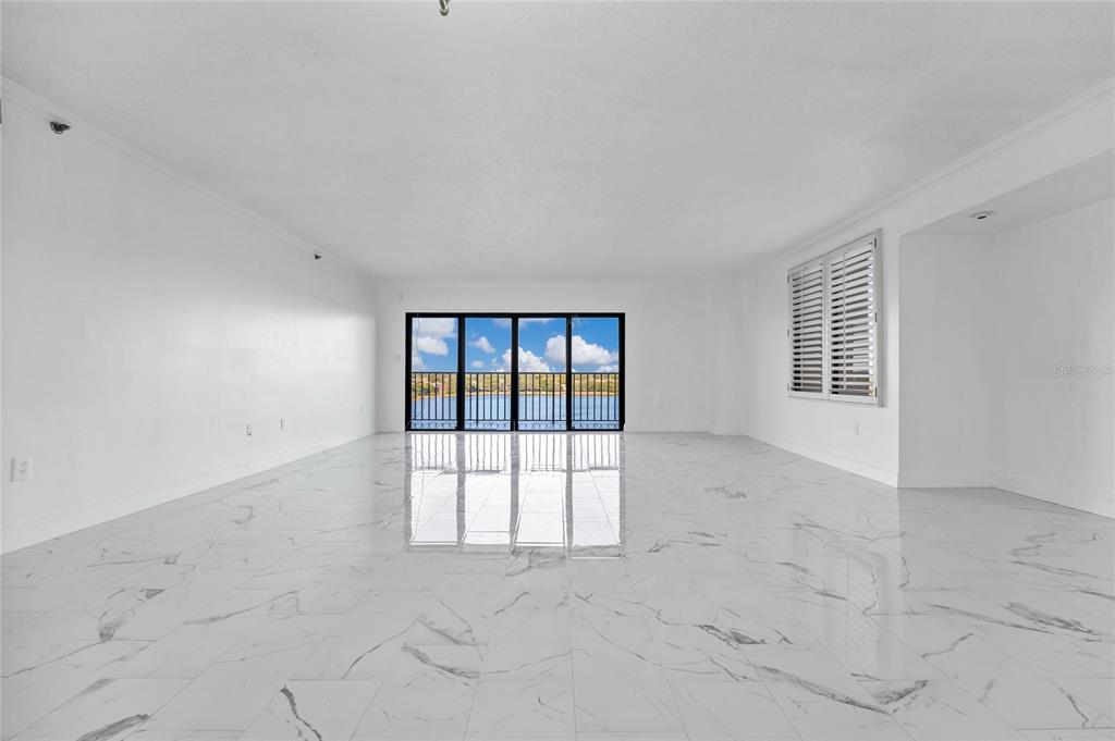 An empty room with white marble floors, white walls, and a large sliding glass door — 7550 HINSON STREET UNIT 10A, ORLANDO, FL