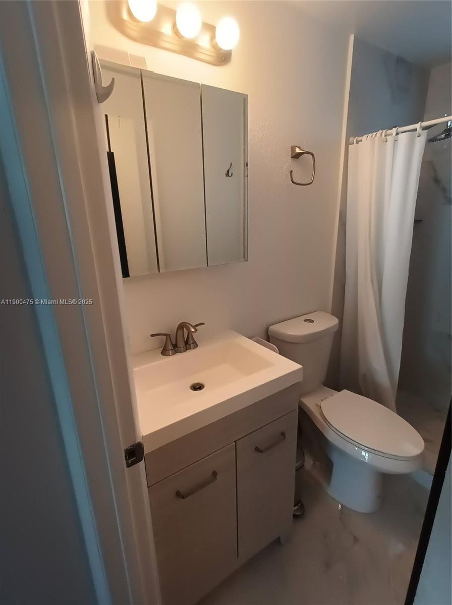 A bathroom features a vanity with a sink, a medicine cabinet, and a shower stall — 300 74th St # 3, Miami Beach FL 33141, MIAMI BEACH, FL