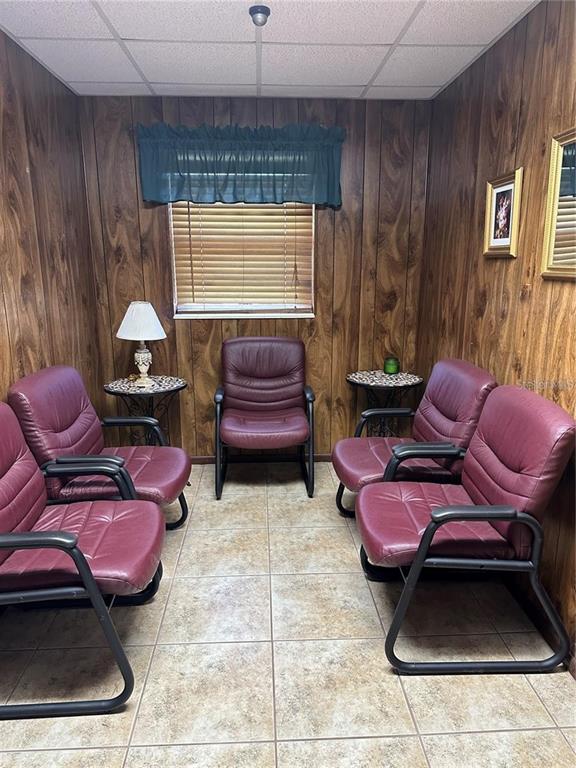 A small waiting room features wood-paneled walls, tile flooring, and five burgundy armchairs — 602 HATHAWAY AVENUE, BRONSON, FL