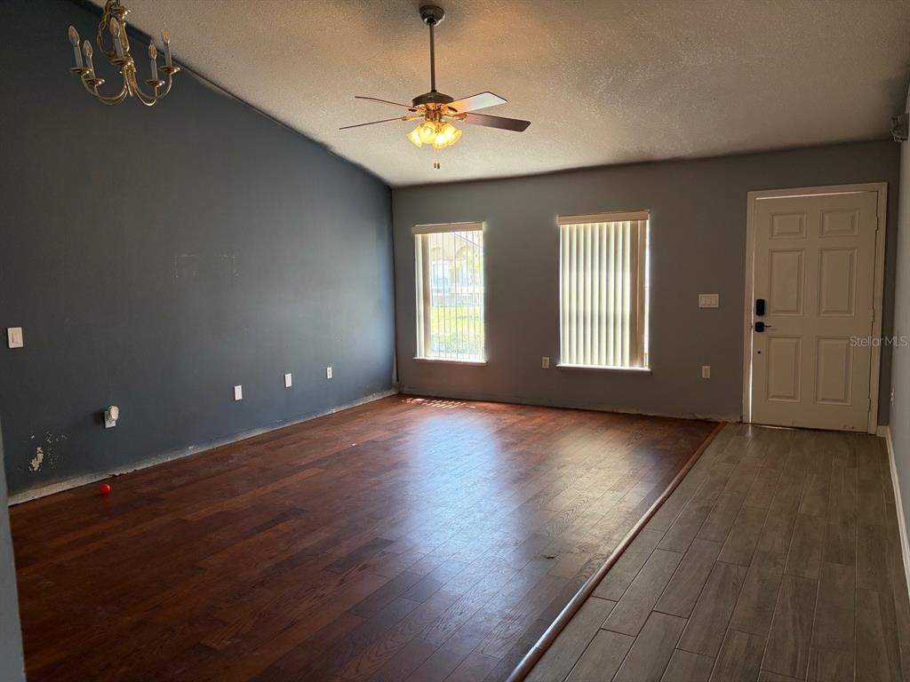 A living room features hardwood floors, a ceiling fan, and arched wall niches — 135 VERVAIN AVENUE, DAVENPORT, FL