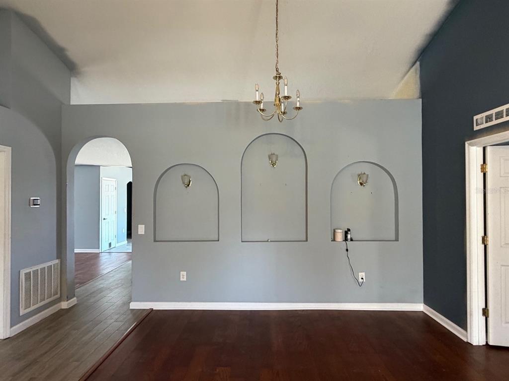 An empty room features dark wood flooring, a purple accent wall, and a ceiling fan — 135 VERVAIN AVENUE, DAVENPORT, FL