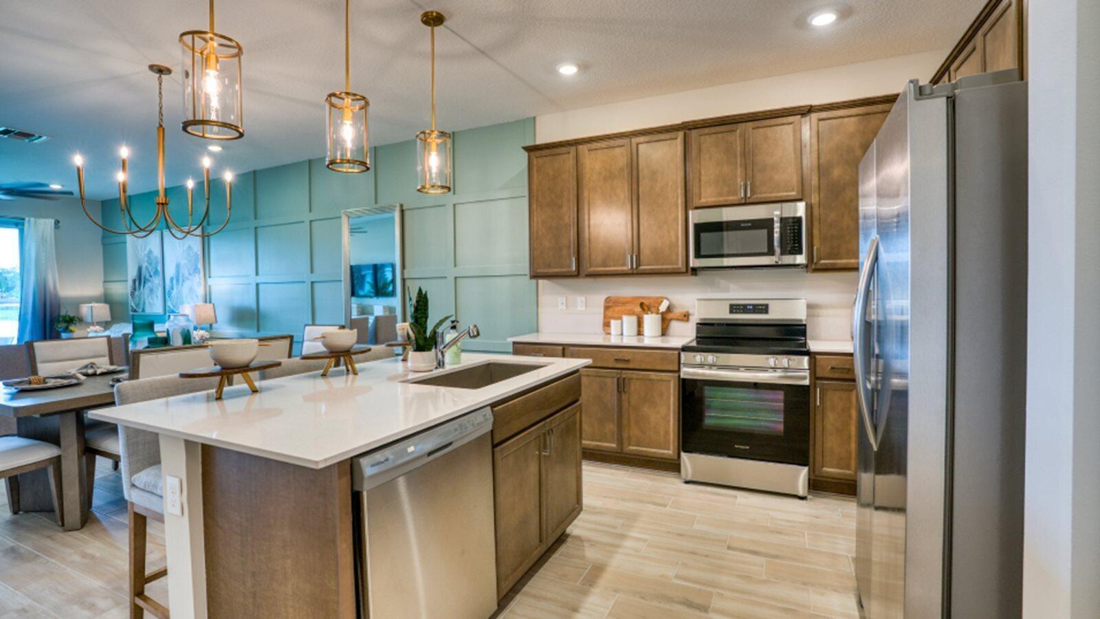 A modern kitchen features wood cabinets, stainless steel appliances, and a large white island — 13658 Jubilee Lane, Delray Beach FL 33484, DELRAY BEACH, FL