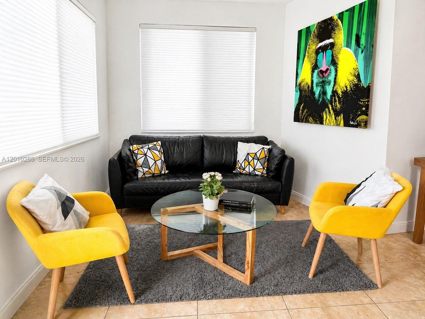 A living room features a black leather sofa, two yellow chairs, and a glass coffee table — 135 NW 68th St, Miami FL 33150, MIAMI, FL