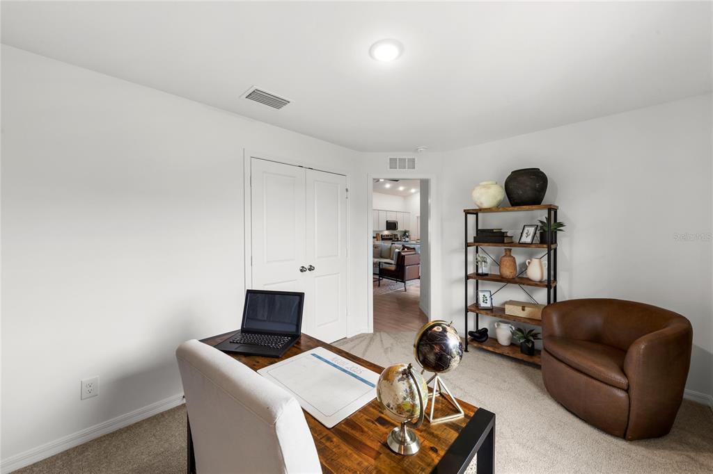 A home office features a desk with a laptop, a bookshelf, and a leather armchair — 7608 N PRIMROSE DRIVE, CITRUS SPRINGS, FL
