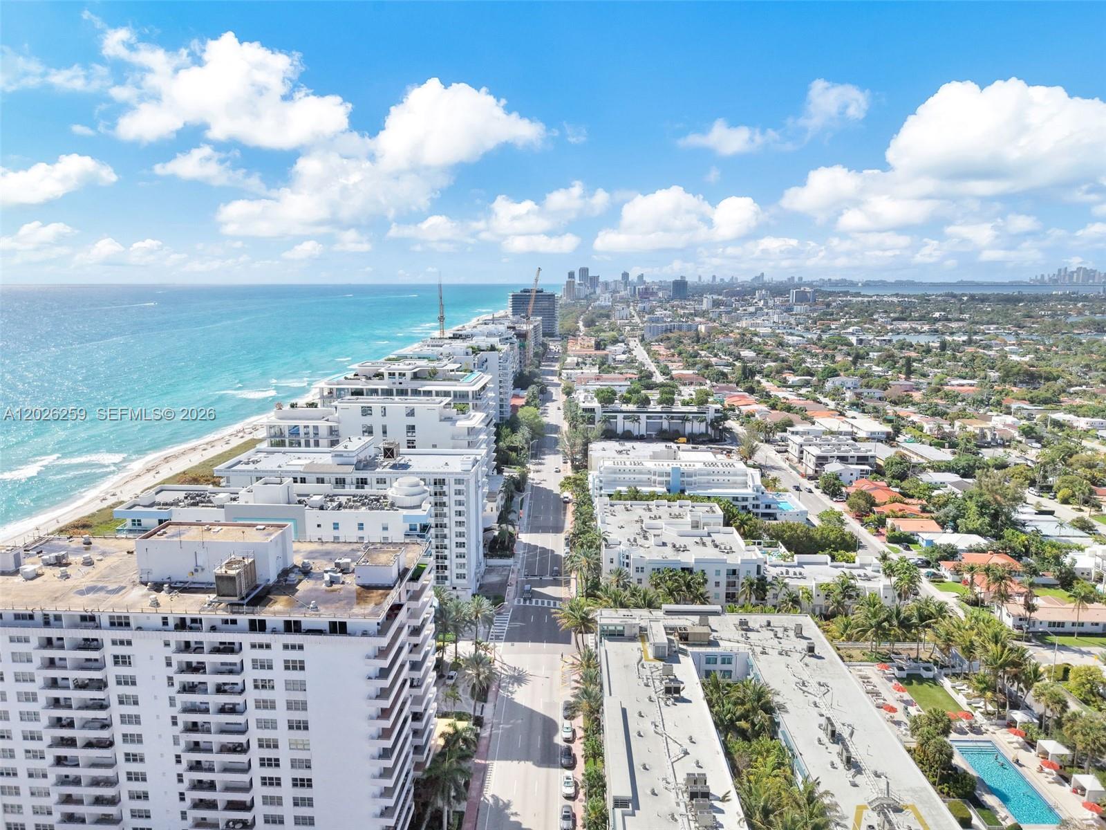 An aerial view shows a coastal city with high-rise buildings, a beach, and a road — 9201 Collins Ave # 821, Surfside FL 33154, SURFSIDE, FL