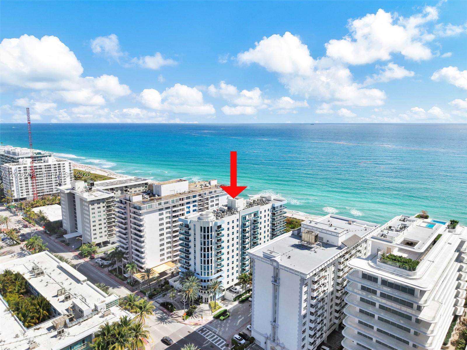 An aerial view shows a multi-story beachfront condominium building marked by a red arrow — 9201 Collins Ave # 821, Surfside FL 33154, SURFSIDE, FL