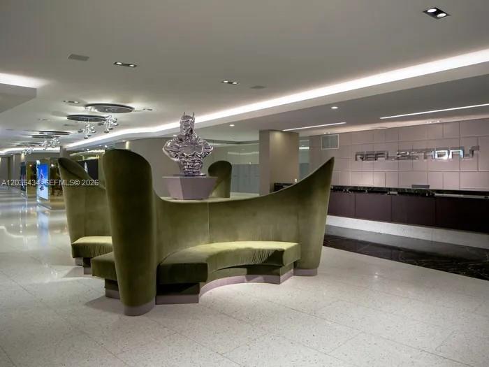 A modern lobby features a curved green velvet sofa and a metallic sculpture — 1000 NW 7th St # 710, Miami FL 33136, MIAMI, FL