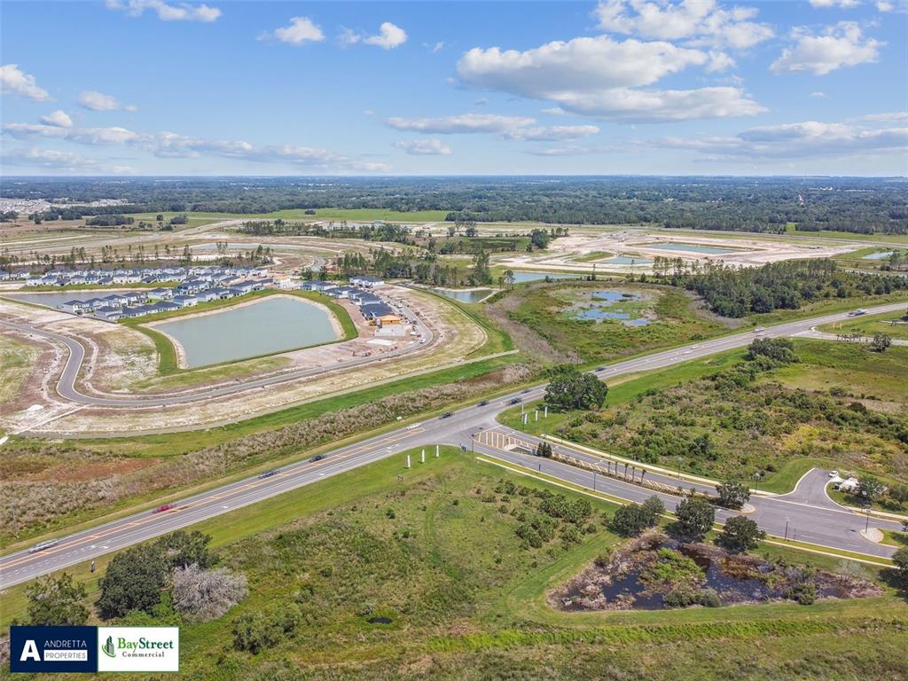 An aerial view shows a residential development under construction near a highway and wetlands — 0 N GALL BOULEVARD UNIT 1.08 Acres, ZEPHYRHILLS, FL