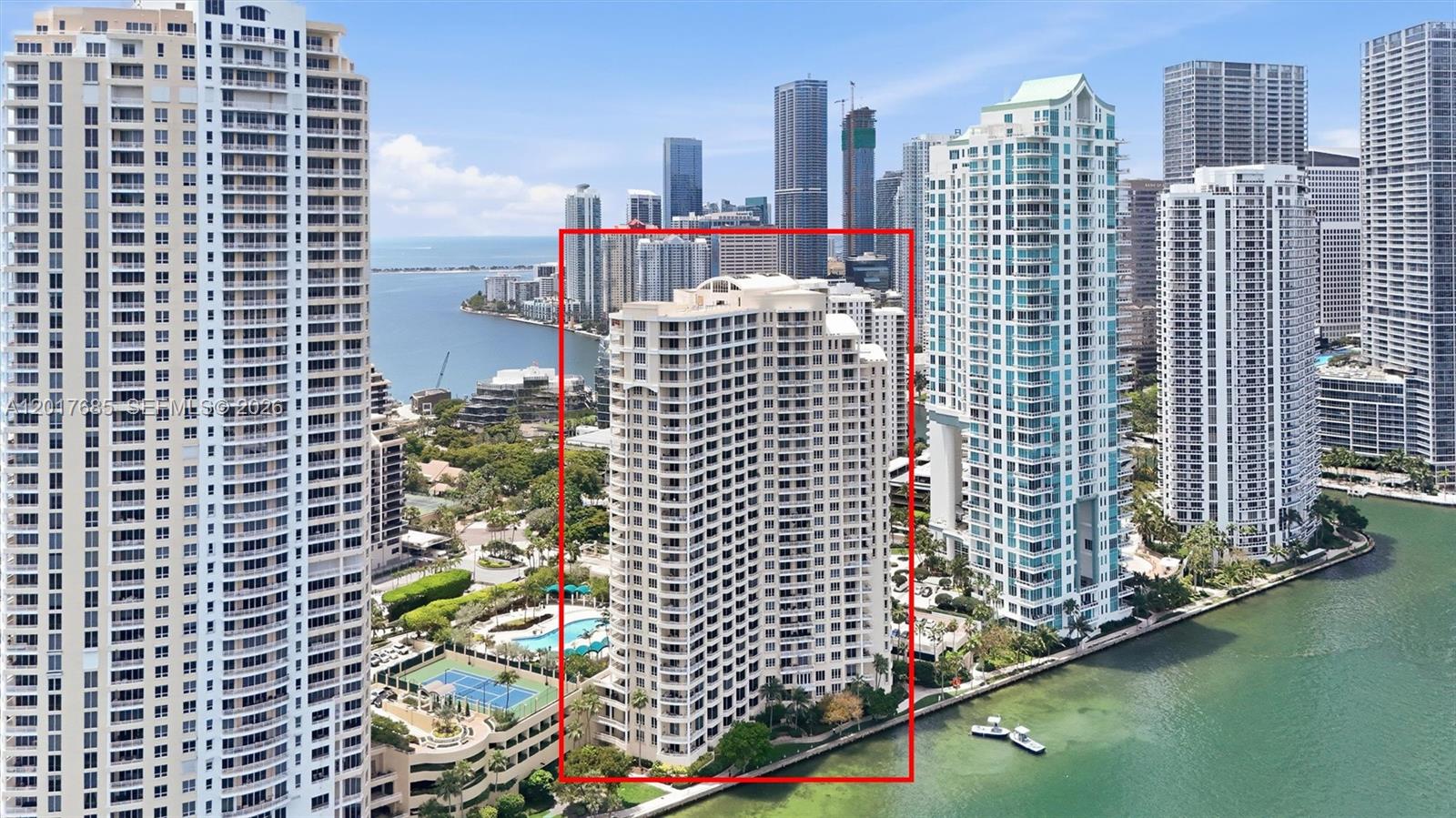 An aerial view shows a tall, light-colored residential building surrounded by other high-rise towers — 888 Brickell Key Dr # 2010, Miami FL 33131, MIAMI, FL