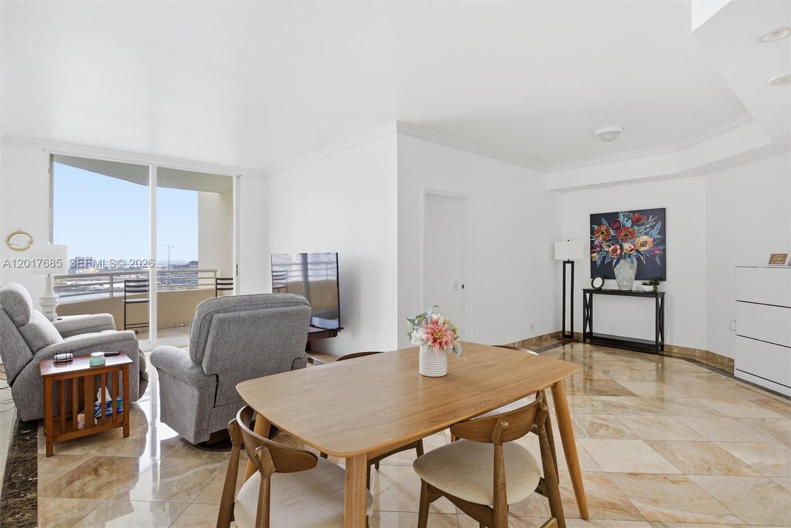A dining area and living space feature marble floors, neutral walls, and a balcony view — 888 Brickell Key Dr # 2010, Miami FL 33131, MIAMI, FL