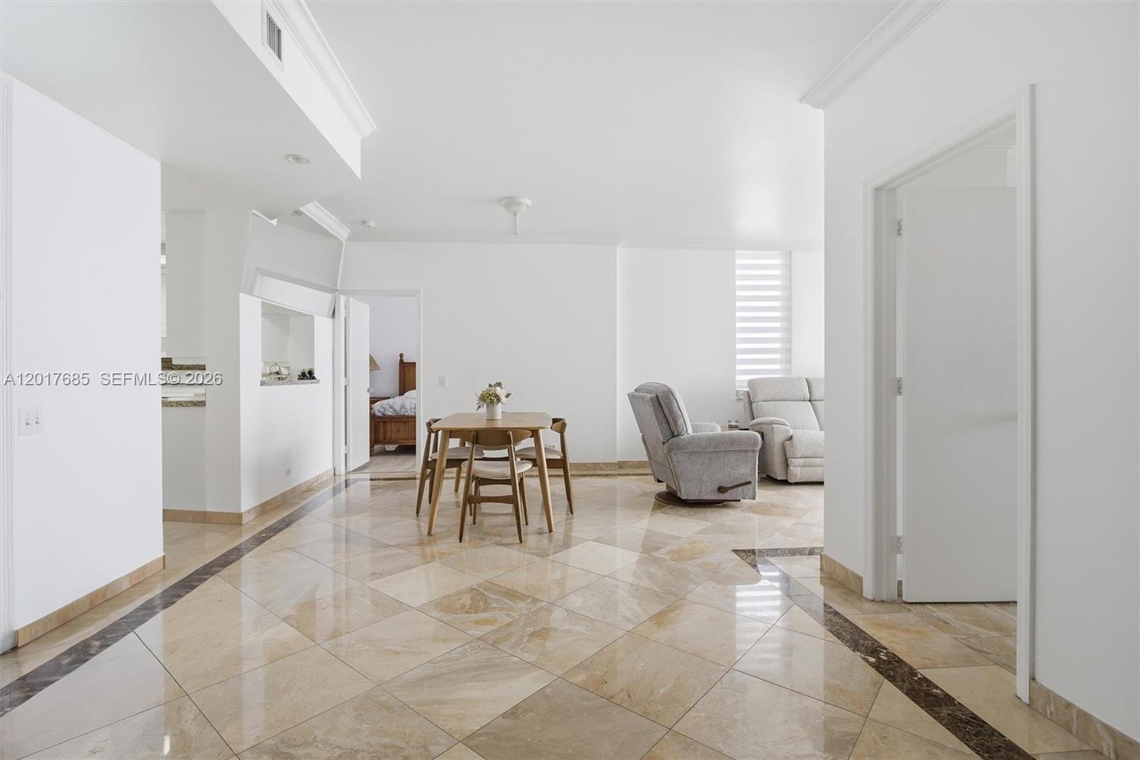 A dining area and living space feature light-colored tile floors with dark decorative borders — 888 Brickell Key Dr # 2010, Miami FL 33131, MIAMI, FL