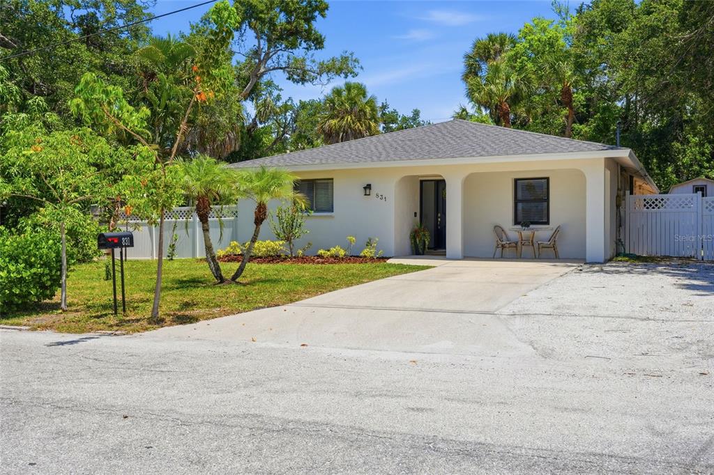 A single-story house with a white exterior, a covered front porch, and a concrete driveway — 831 HIGHLAND STREET, SARASOTA, FL
