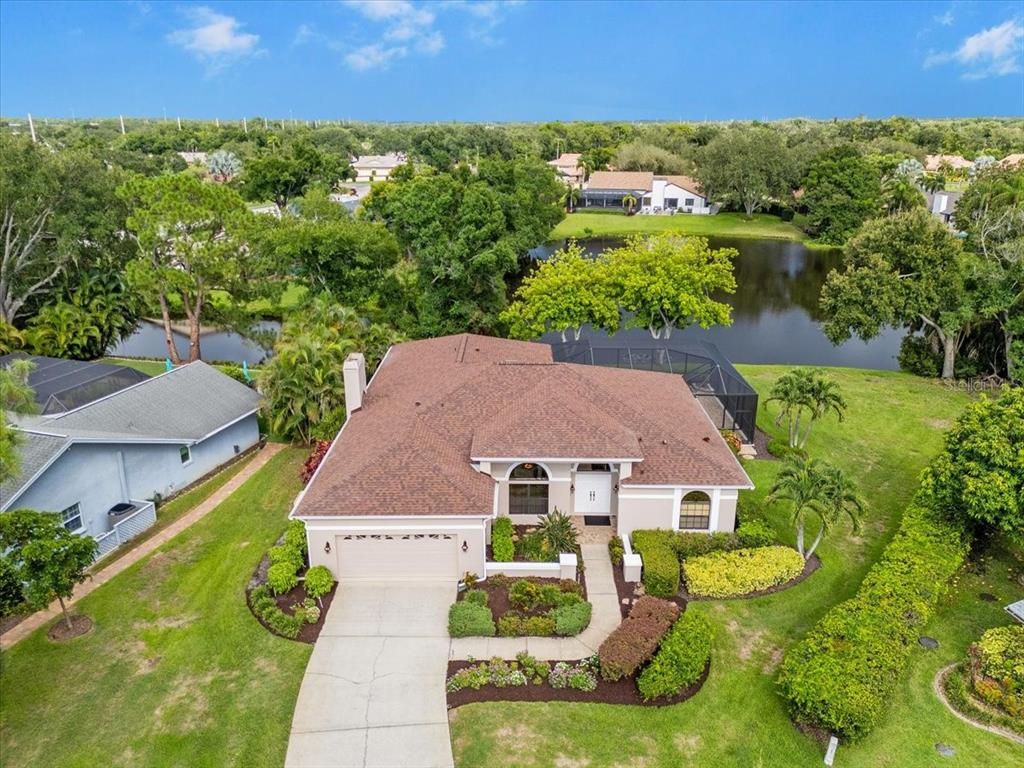 An aerial view of a single-story house with a brown roof and a backyard pool enclosure — 4451 CAICOS COURT, SARASOTA, FL