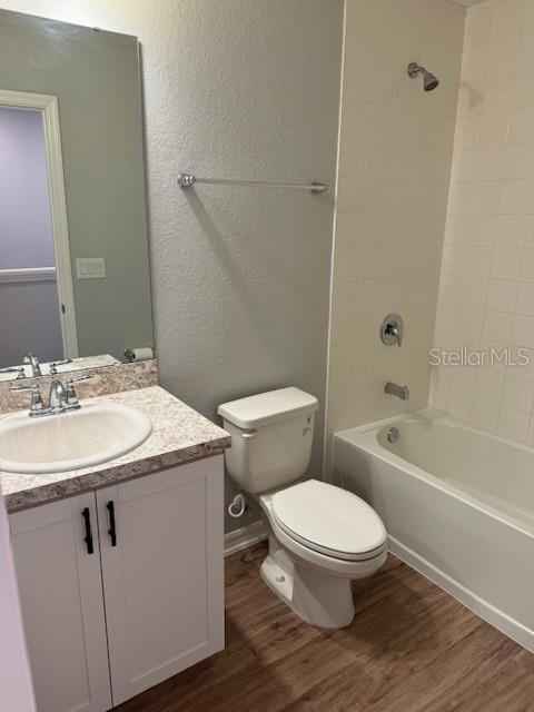 A bathroom features a white vanity, a toilet, and a shower-tub combination with tiled walls — 3071 FIELDWOOD CIRCLE, ST CLOUD, FL