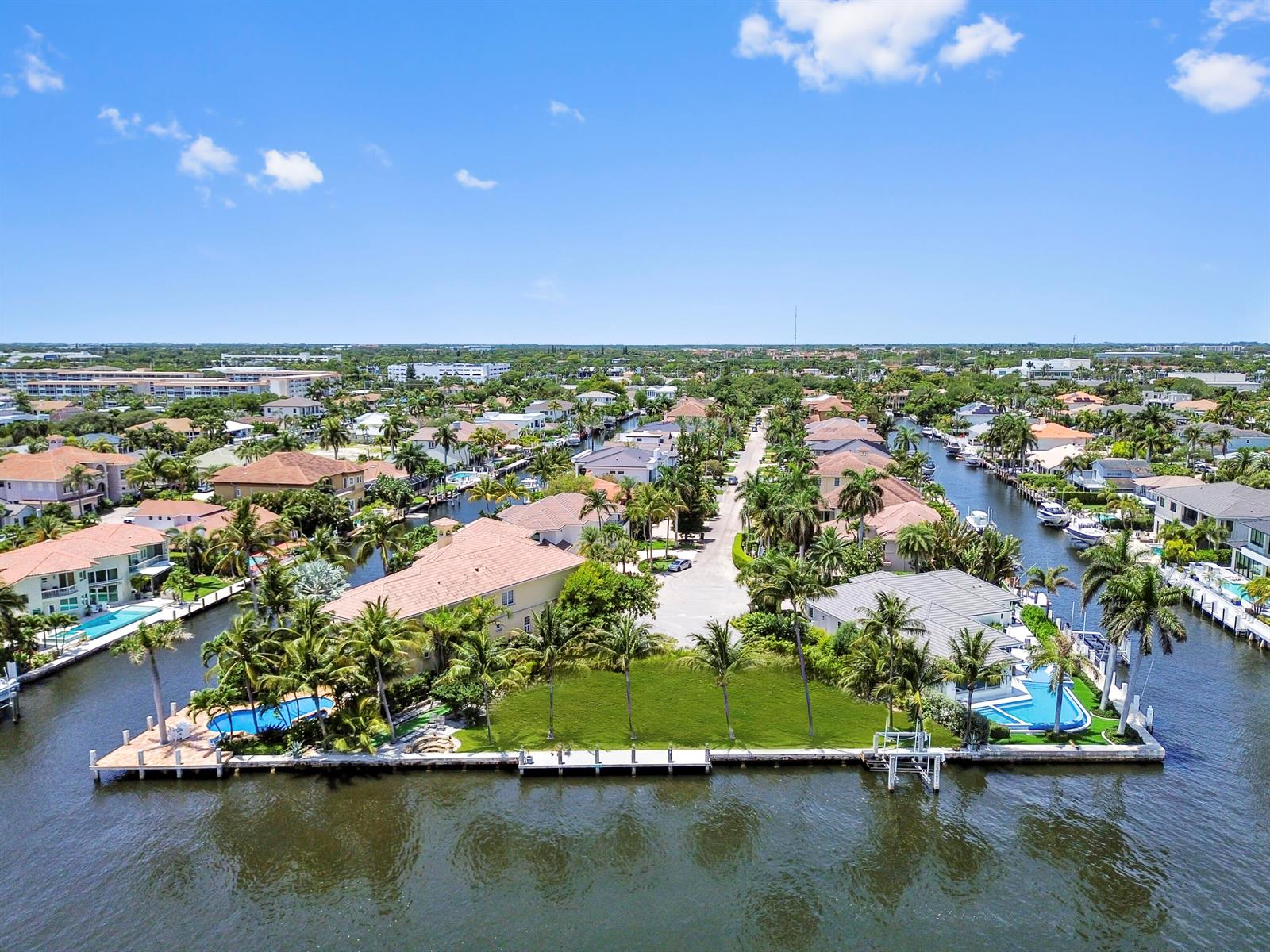 An aerial view shows a waterfront residential property with a large lawn and private docks — 976 Banyan Drive, Delray Beach FL 33483, DELRAY BEACH, FL