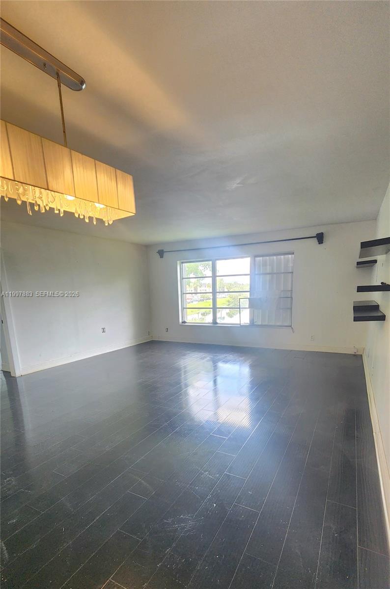 A room with dark wood flooring, a chandelier, and a kitchen island with granite countertops — 3811 NW 84th Ave # 2B, Sunrise FL 33351, SUNRISE, FL