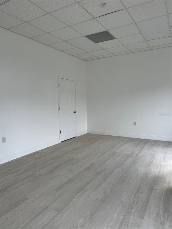 An empty room features white walls, light wood-look flooring, and a drop ceiling — 6315 OLD WINTER GARDEN ROAD, ORLANDO, FL