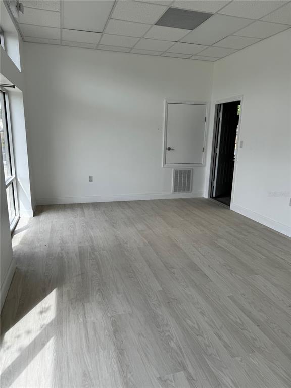 An empty office space with white walls, light wood-look flooring, and a drop ceiling — 6315 OLD WINTER GARDEN ROAD, ORLANDO, FL