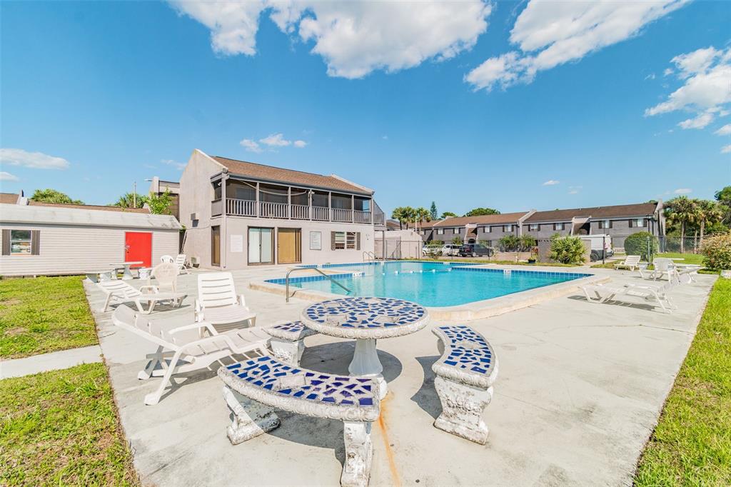 A modern kitchen features white cabinets, stainless steel appliances, a subway tile backsplash, and wood flooring — 4036 CORTEZ DRIVE UNIT A, TAMPA, FL