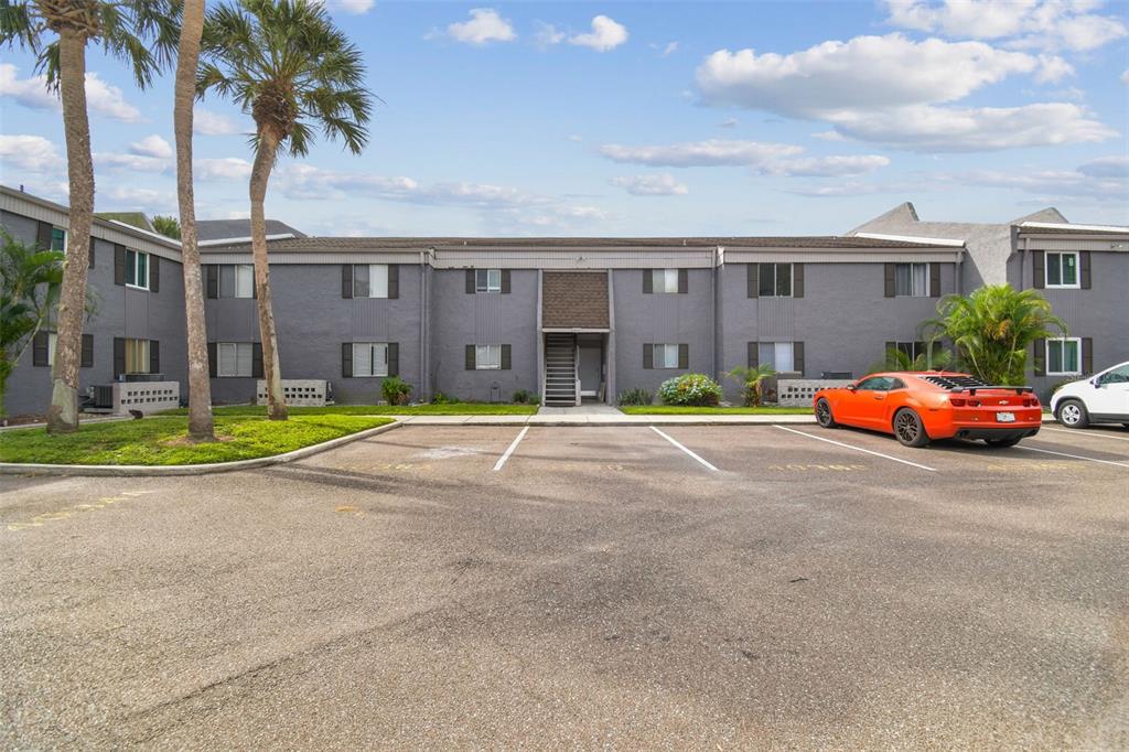 A screened-in porch overlooks a grassy lawn and a pond filled with lily pads — 4036 CORTEZ DRIVE UNIT A, TAMPA, FL