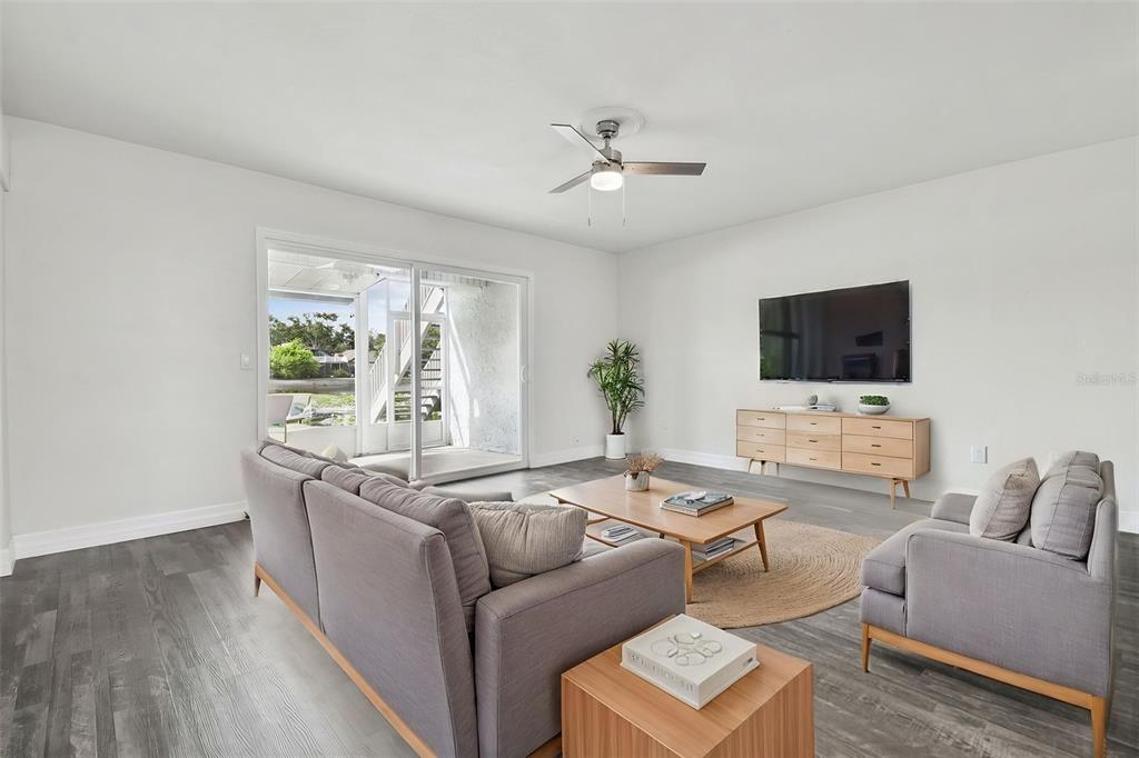 A swimming pool sits on a concrete patio with outdoor seating and nearby apartment buildings — 4036 CORTEZ DRIVE UNIT A, TAMPA, FL