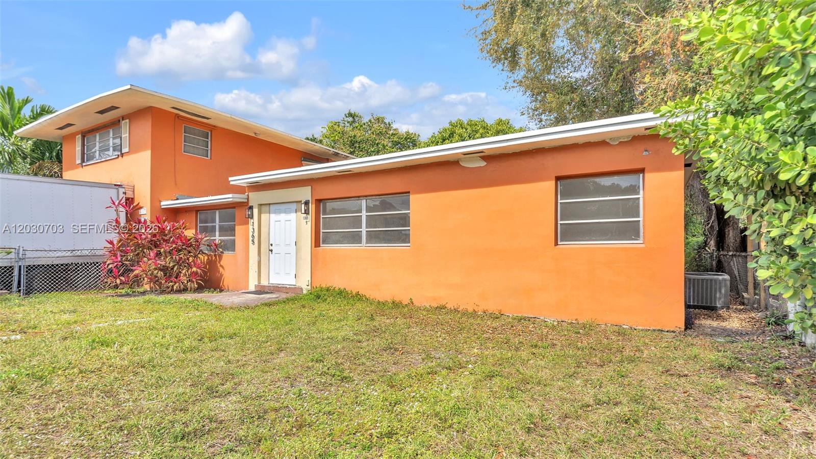 A two-story orange house with a flat roof and a front-facing entrance — 1365 NW 55th Ter # B, Miami FL 33142, MIAMI, FL