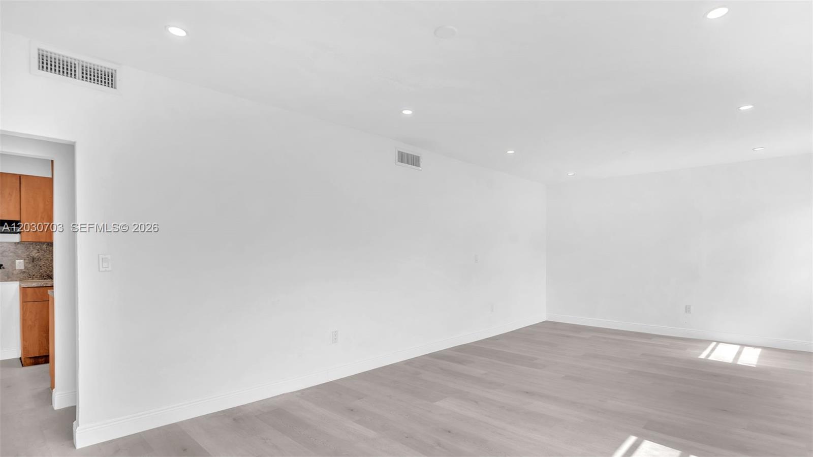 An empty room with white walls, recessed lighting, and light-colored wood flooring — 1365 NW 55th Ter # B, Miami FL 33142, MIAMI, FL