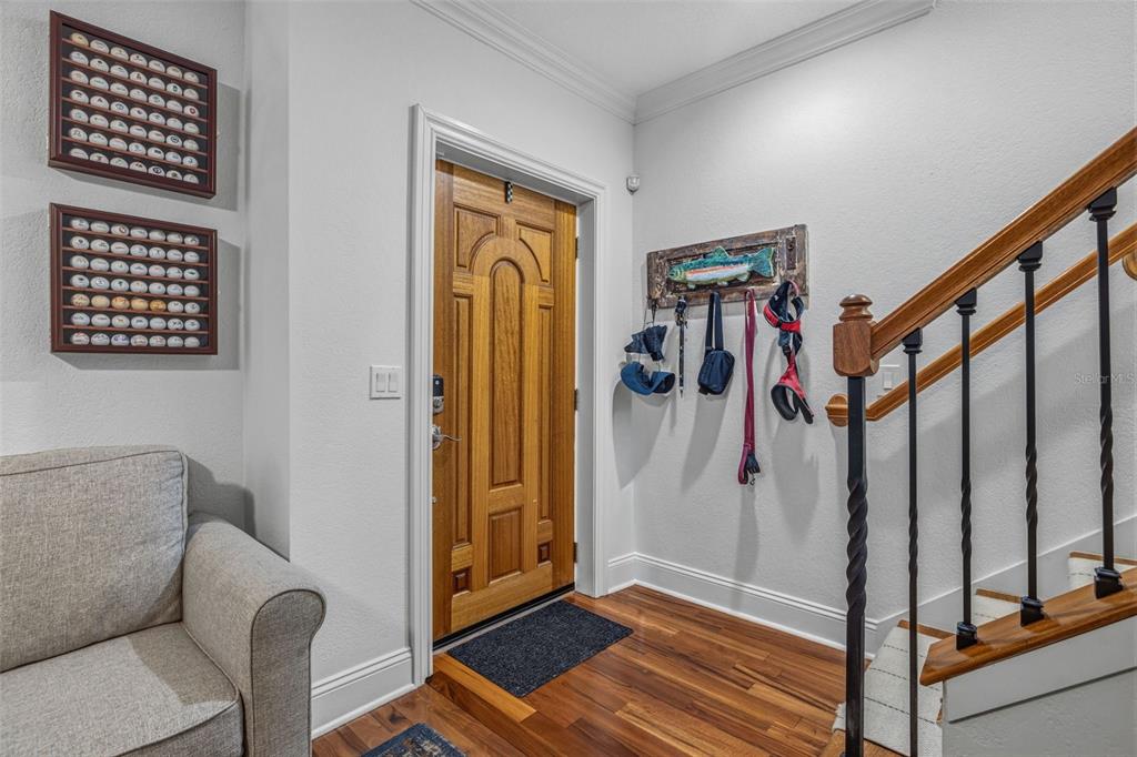 An entryway features a wooden front door, a staircase with iron railings, and wall-mounted decor — 2234 SOHO BAY CT, TAMPA, FL