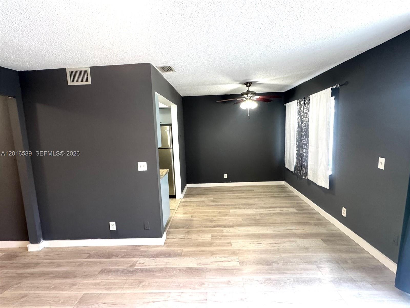 A dining area features dark gray walls, light wood-look flooring, and a ceiling fan — 5908 NW 21st St # A, Lauderhill FL 33313, LAUDERHILL, FL
