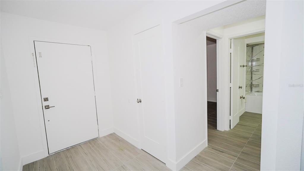 A white front door opens into a tiled entryway with two interior doors and flooring — 4368 S LAKE ORLANDO PARKWAY UNIT 203, ORLANDO, FL