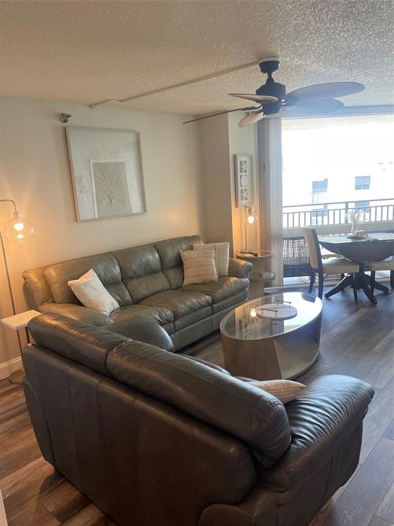 A living room features two leather sofas, a glass coffee table, and a ceiling fan — 690 ISLAND WAY UNIT 1112, CLEARWATER BEACH, FL