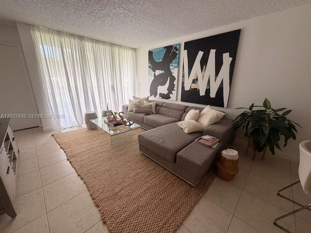 A living room features a gray sectional sofa, large abstract wall art, and a jute rug — 4733 NW 97th Ct # 45, Doral FL 33178, DORAL, FL