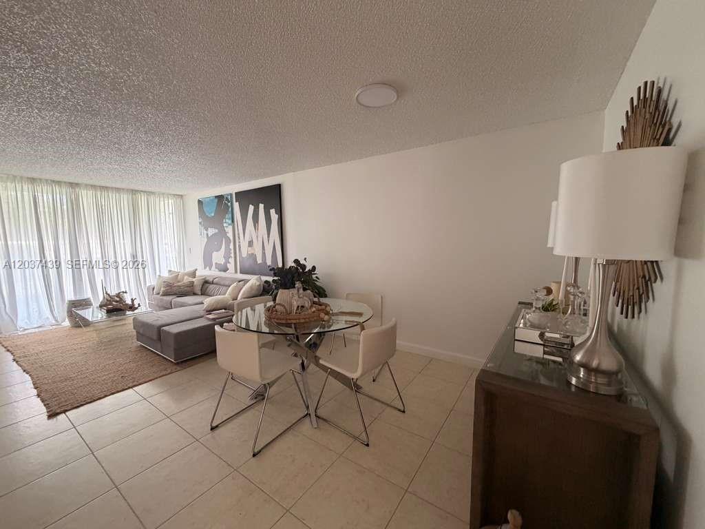 A living and dining area features tile floors, a glass table, and floor-to-ceiling curtains — 4733 NW 97th Ct # 45, Doral FL 33178, DORAL, FL