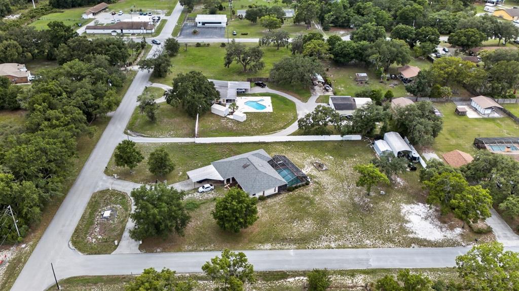 An aerial view shows a residential property with a house, pool, and detached garage — 11501 MINNIEOLA DRIVE, NEW PORT RICHEY, FL