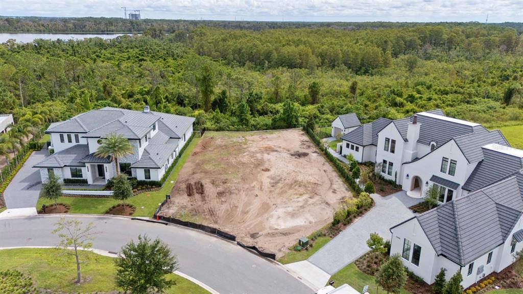 An aerial view shows a vacant residential lot situated between two large, modern white houses — LOT 41, CROMWELL ROAD, ORLANDO, FL