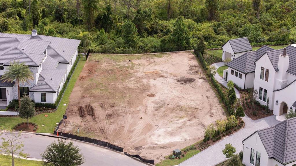 An aerial view shows a vacant, sandy residential lot situated between two modern houses — LOT 41, CROMWELL ROAD, ORLANDO, FL