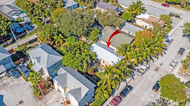 An aerial view shows a residential neighborhood with houses, palm trees, and parked cars — 317 N D Street E, FL 33460, FL