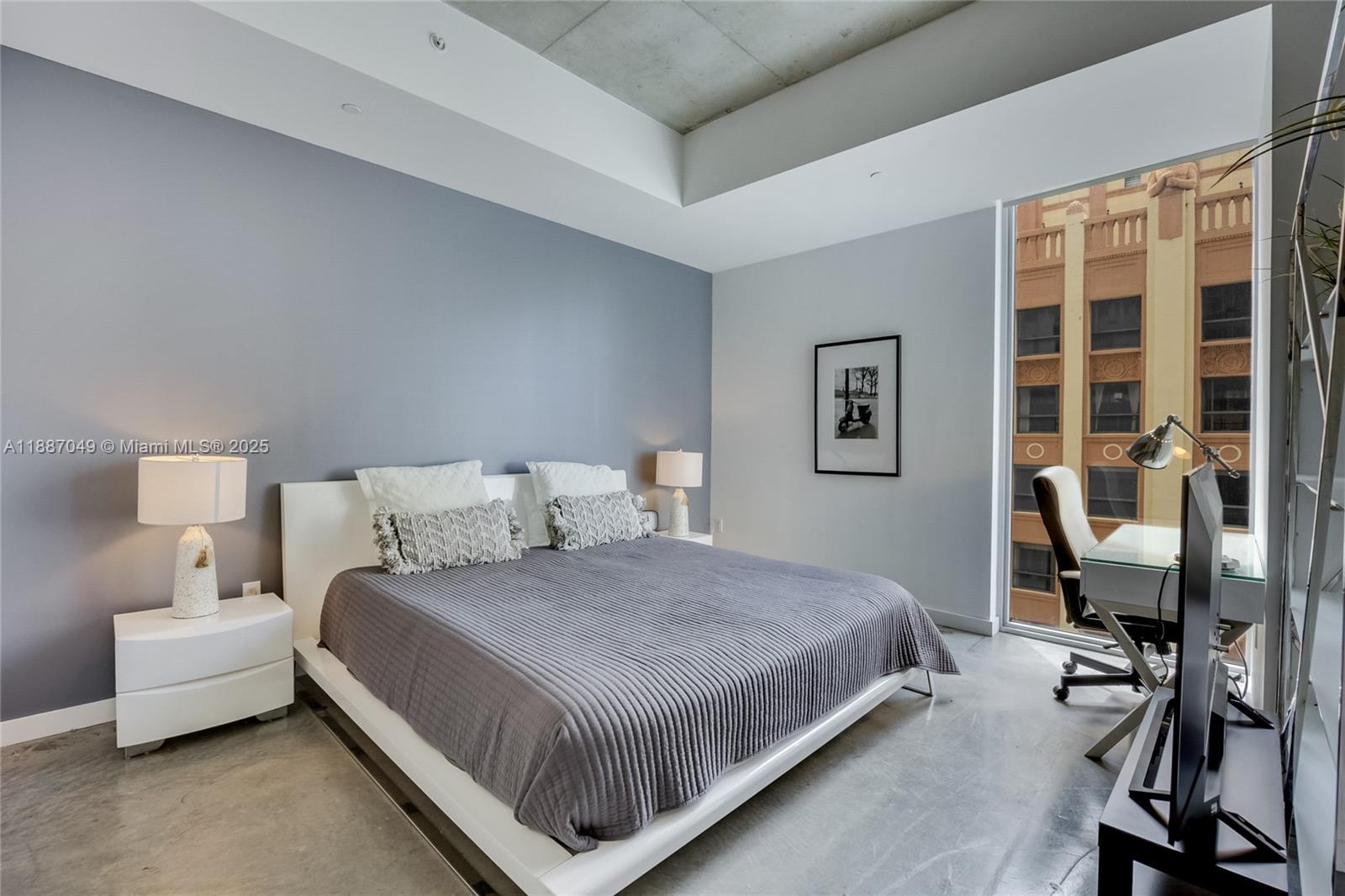 A modern bedroom features a grey accent wall, a platform bed, and a glass desk — 151 SE 1st St # 1003, Miami FL 33131, MIAMI, FL