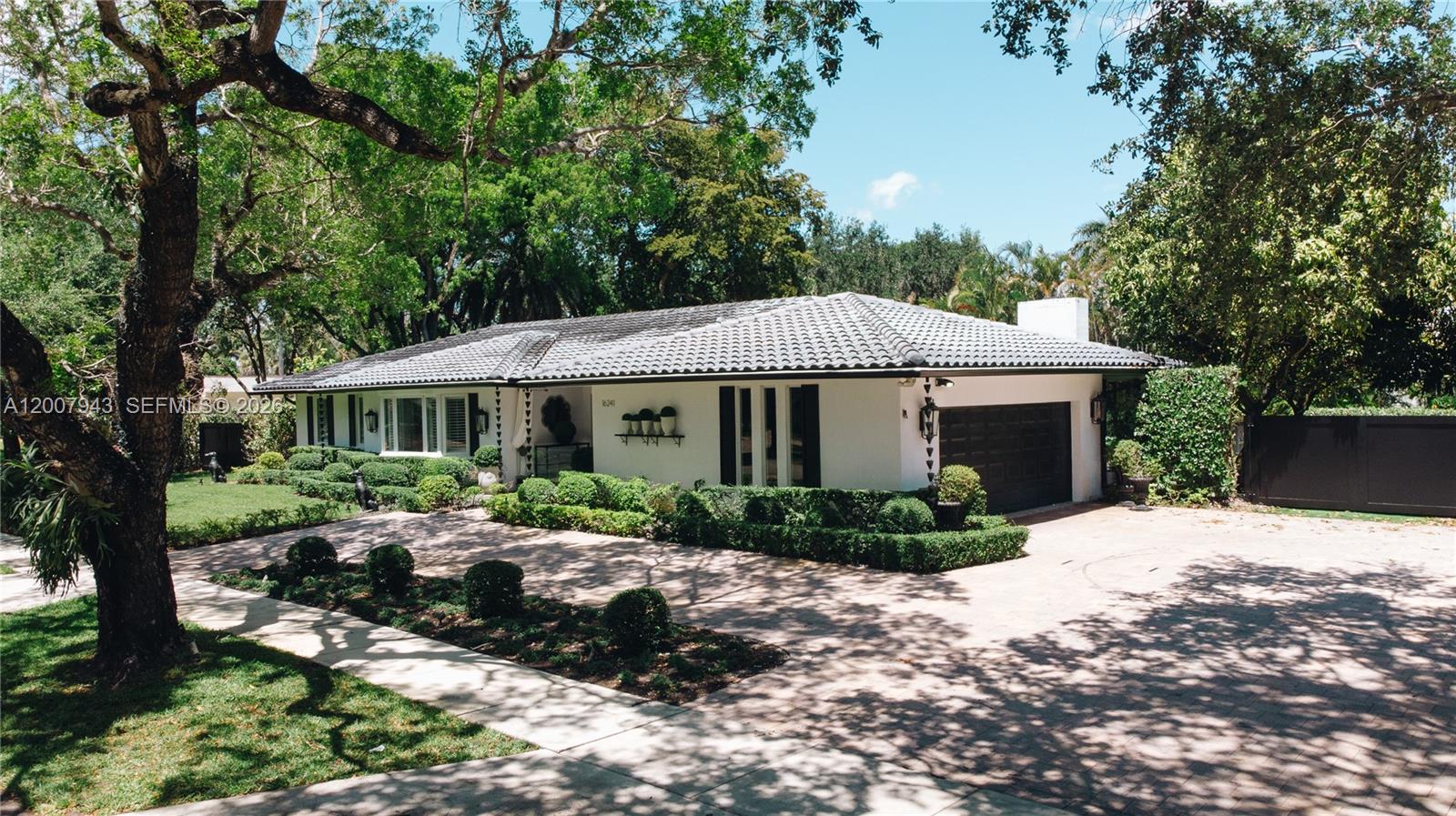 A single-story white house with a tiled roof and a paved driveway surrounded by trees — 16241 W Troon Cir, Miami Lakes FL 33014, MIAMI LAKES, FL