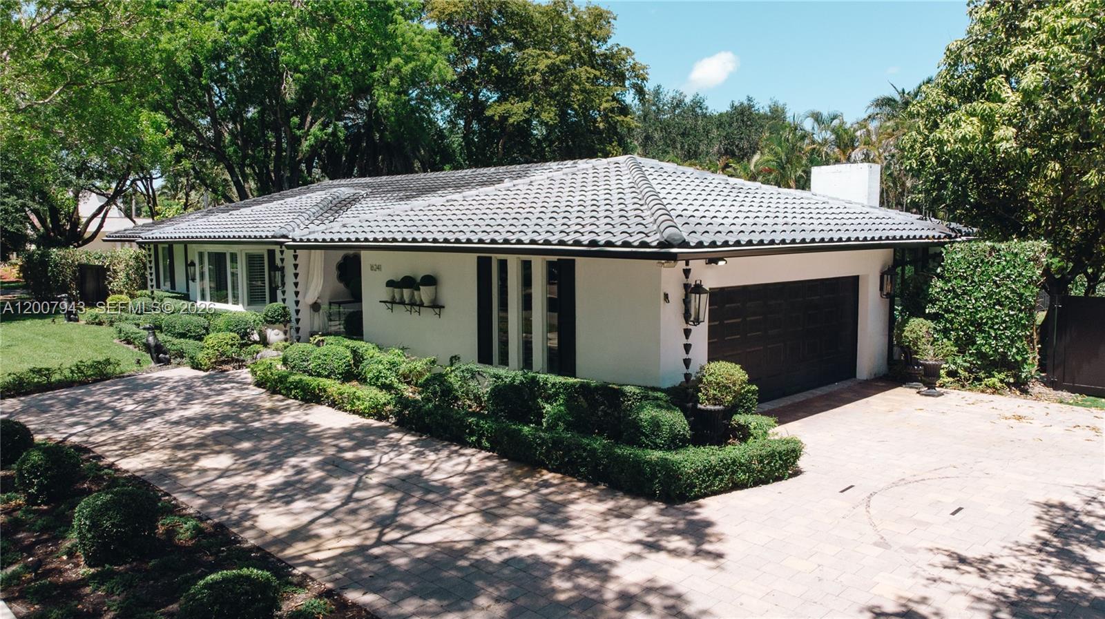 A single-story white house with a dark tiled roof and a paved driveway — 16241 W Troon Cir, Miami Lakes FL 33014, MIAMI LAKES, FL